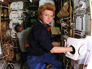 STS-84 Mission Specialists Jean-Francois Clervoy (background) and Elena Kondakova (foreground) work with the Spacehab Biorack glovebox. 